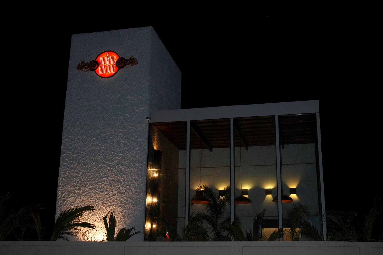 The Cooking Culture exterior at night with the illuminated logo