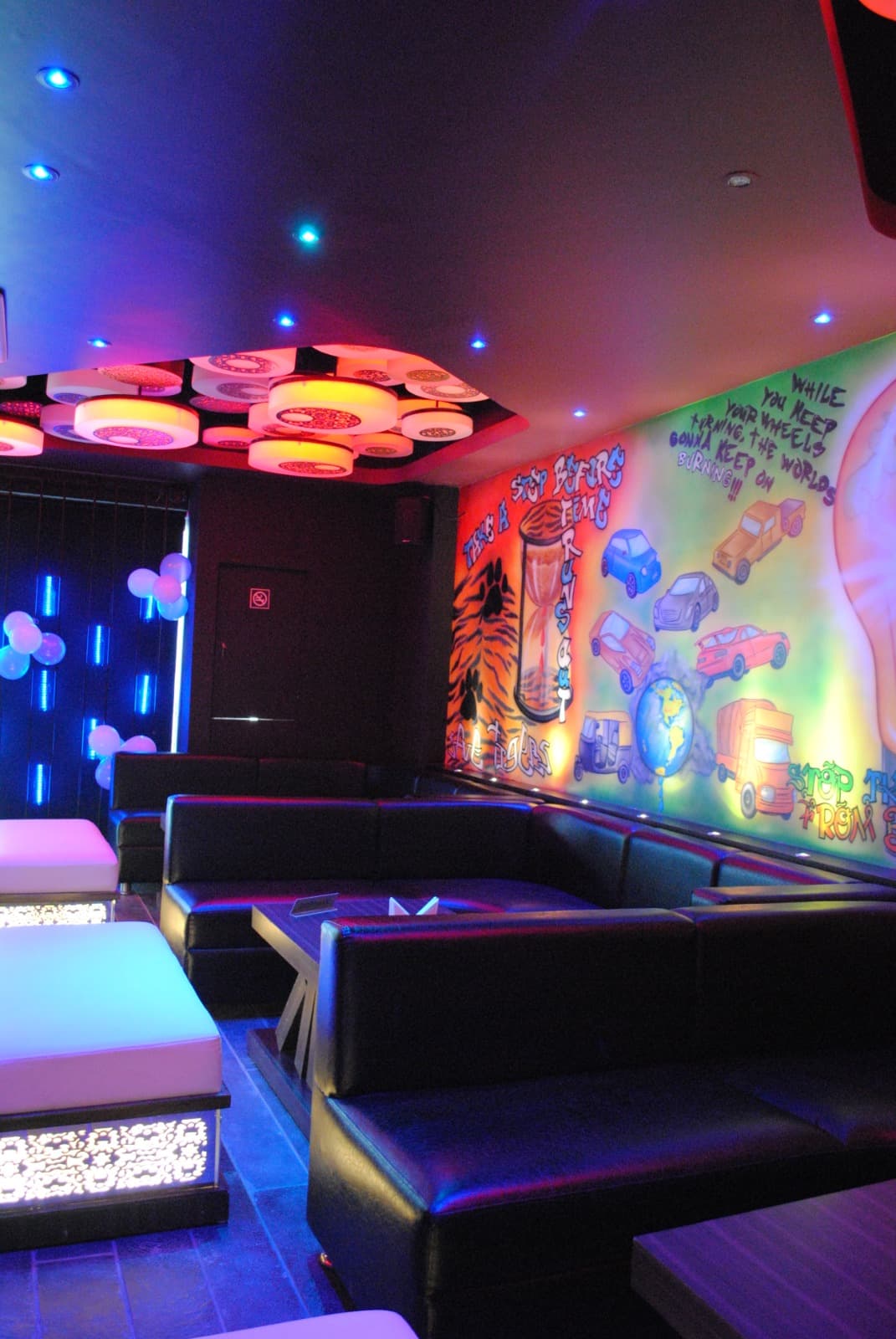 Karma booth seating beside a hand-painted mural wall