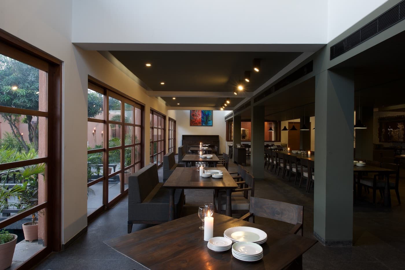 @Mango candle-lit dining tables beside the garden windows