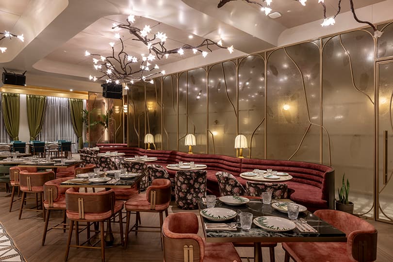 Lounge with red banquettes and chandeliers of blossoming branches