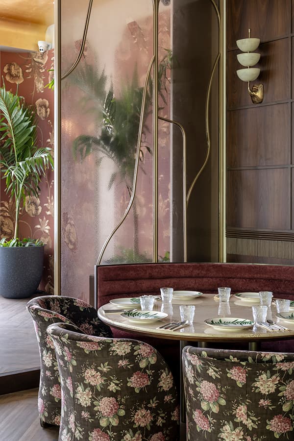 Booth with floral chairs against a botanical wall