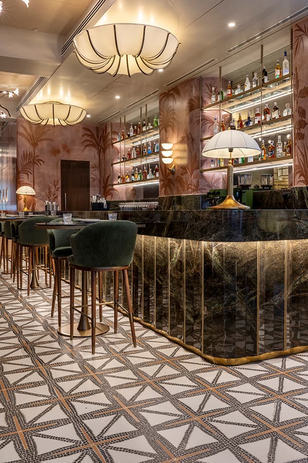 Bar counter with brass trim and geometric tile flooring
