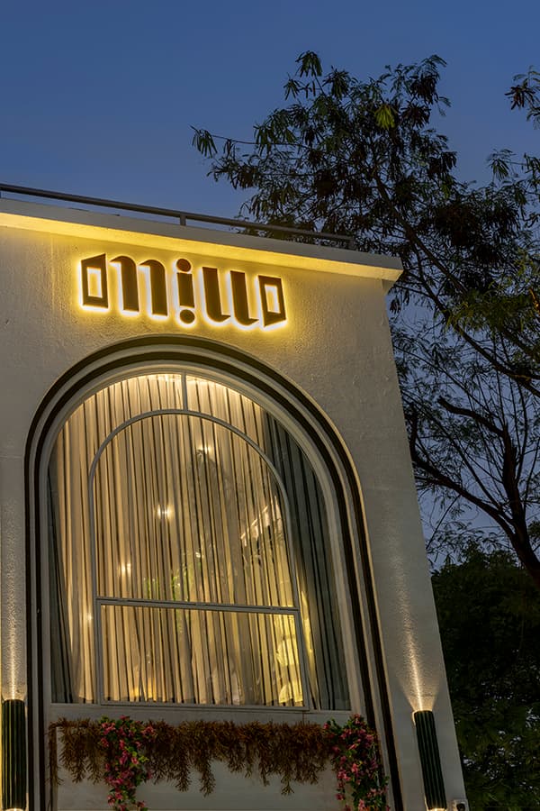 Illuminated Millo Nagpur sign above the arched window