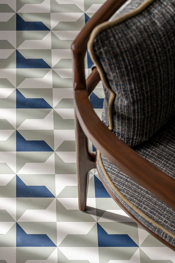 Blue and white tile floor beside a woven-back chair