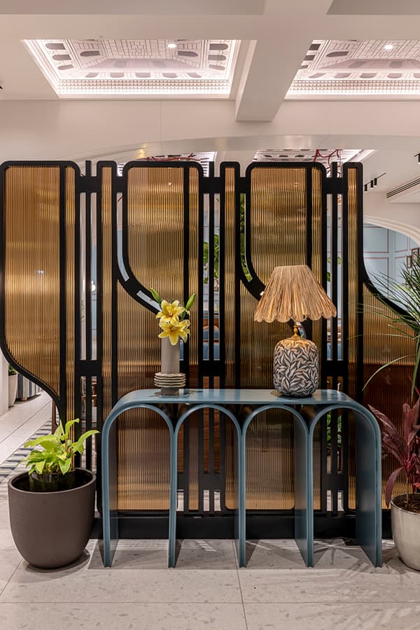Brass fluted screen with a lamp on an arched console