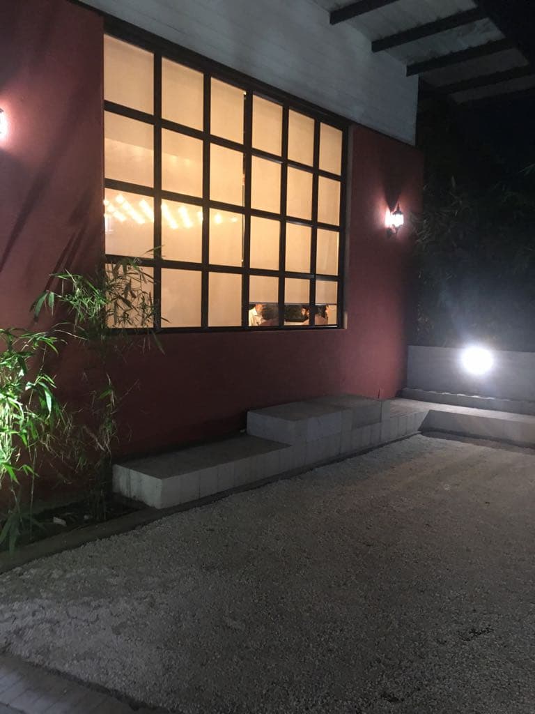 Courtyard seating beside a backlit window wall