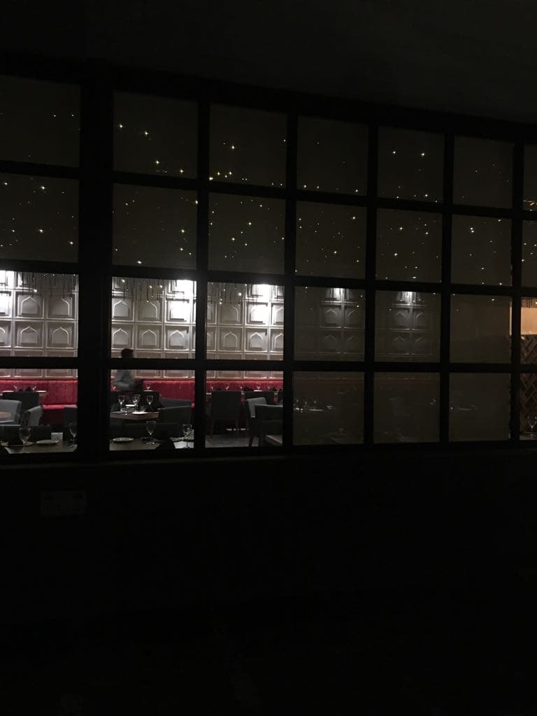 Backlit window wall glowing over the dining room at night