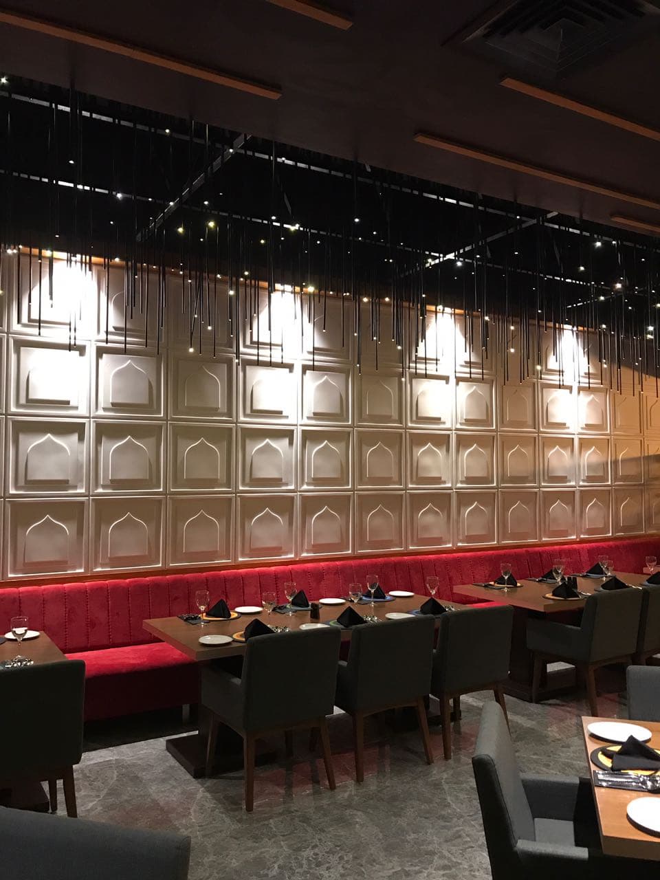 Carved panelled wall and red banquette running the length of the room