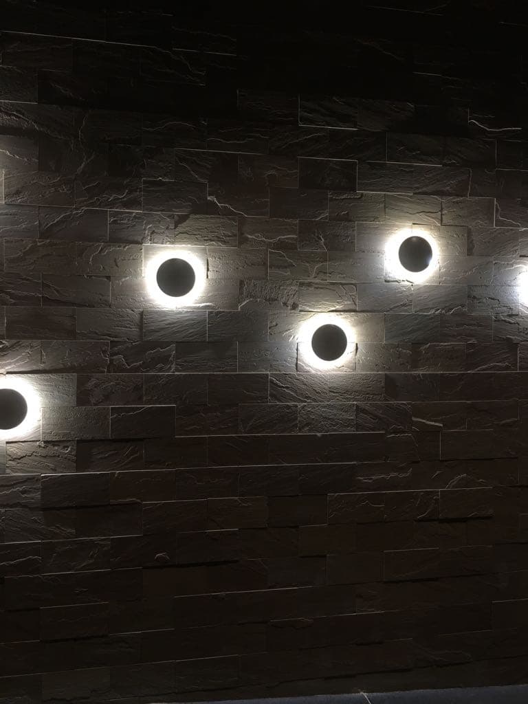 Circular wall lights set into a textured stone wall