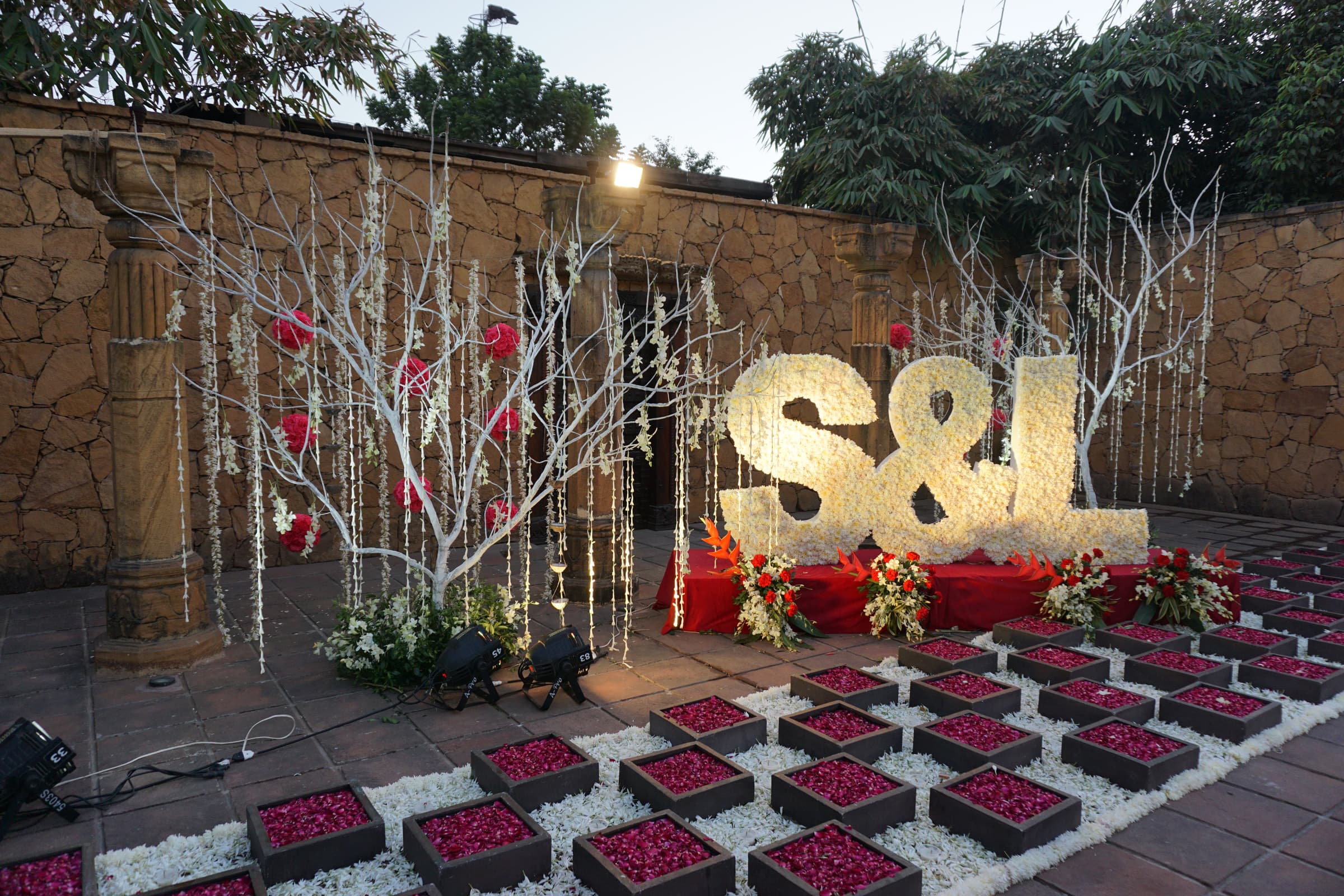 Monogram décor with white branches and a lantern-lined floor