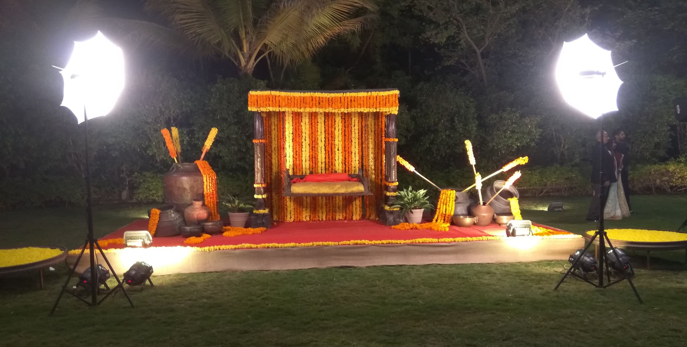 Lit wooden chair stage set beside floodlights on the lawn