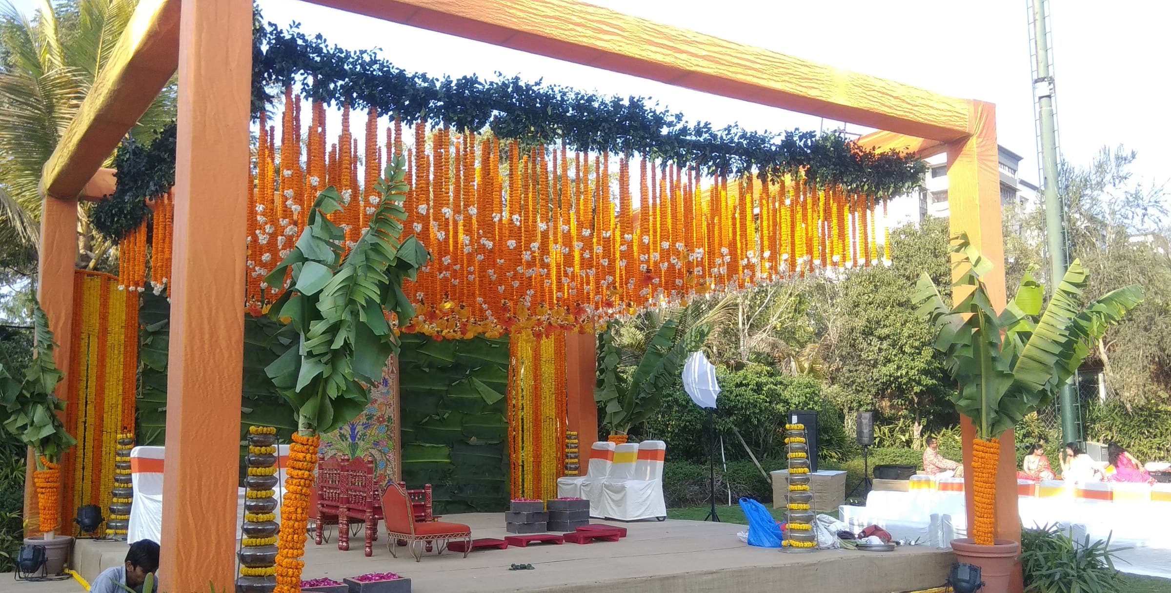 Yellow pavilion draped in marigold and blue garlands
