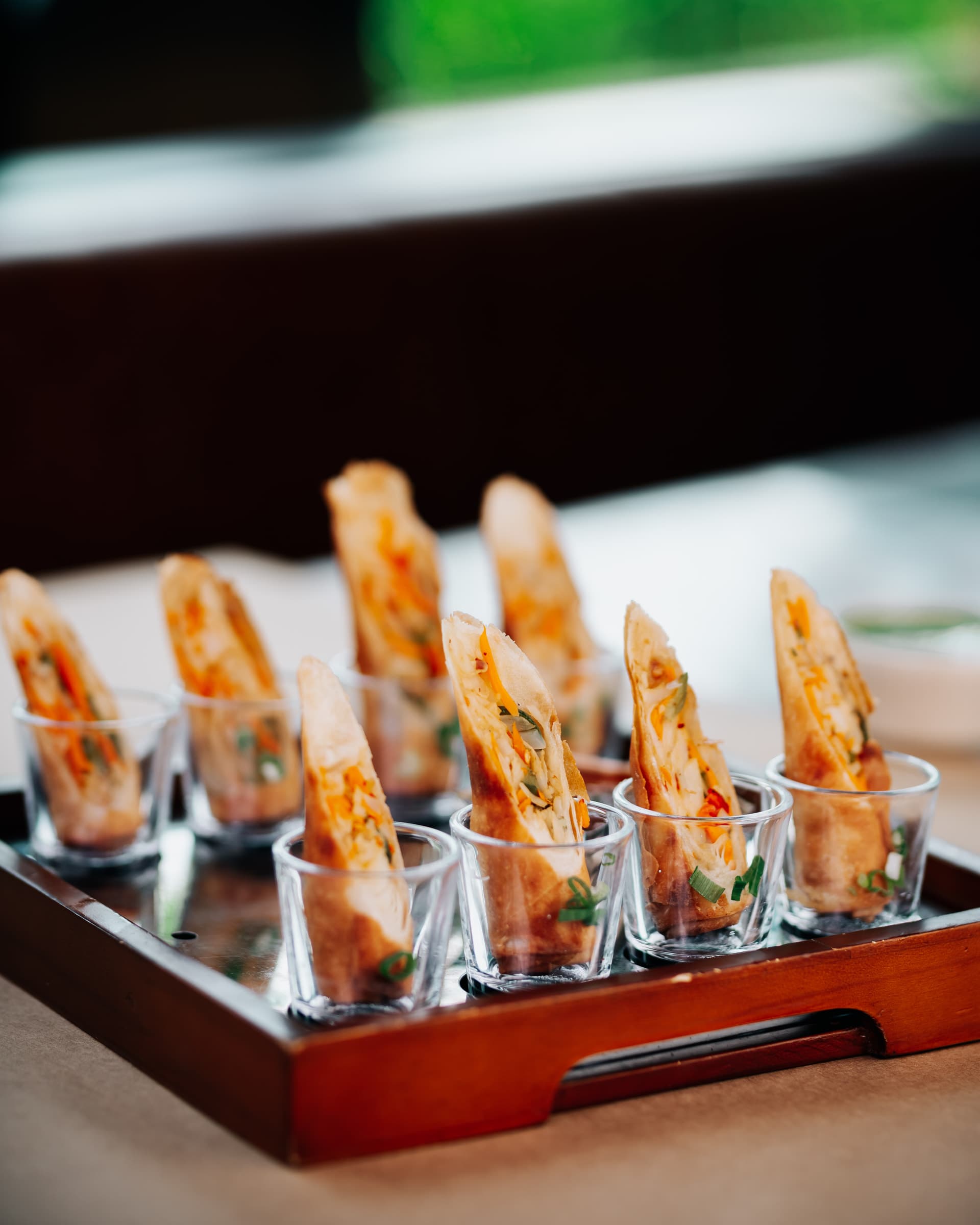 Skewered rolls served in shot glasses on a red tray