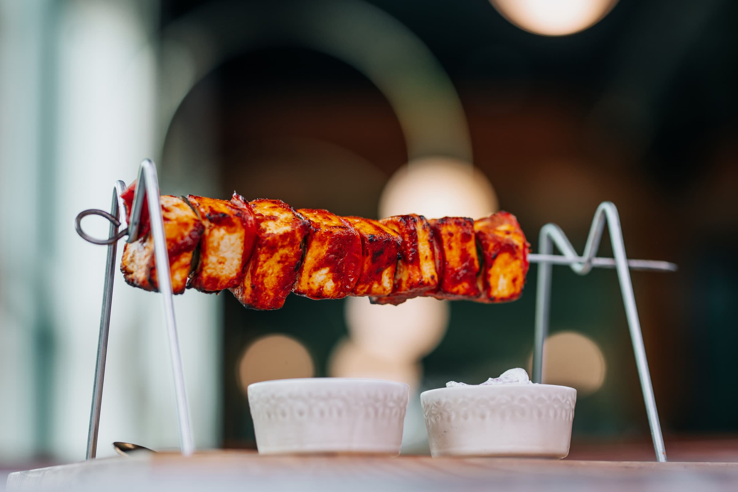 Grilled paneer skewer on a metal stand