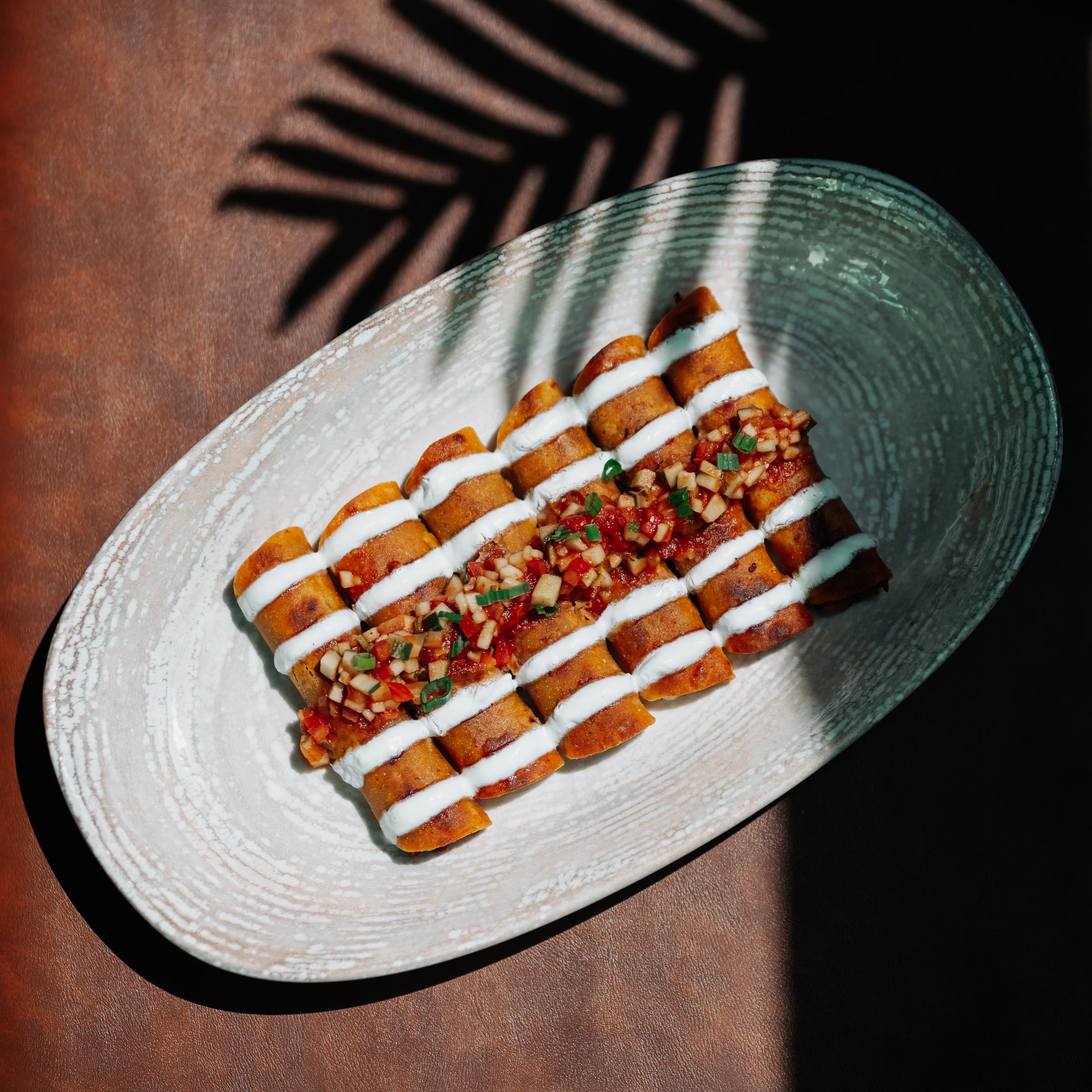 Layered savoury dish with sauce on a green plate