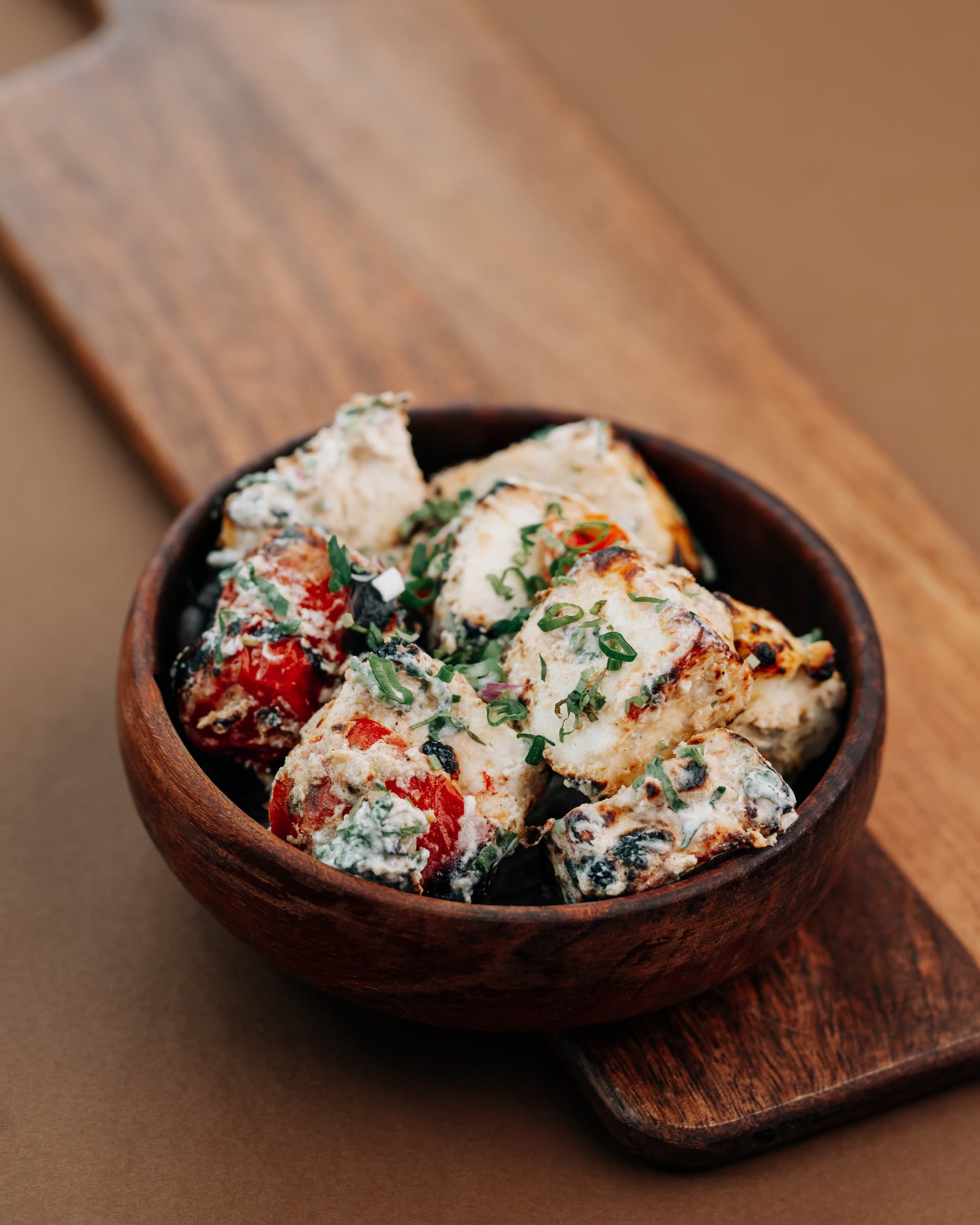 Chaat in a wooden bowl on a wooden board