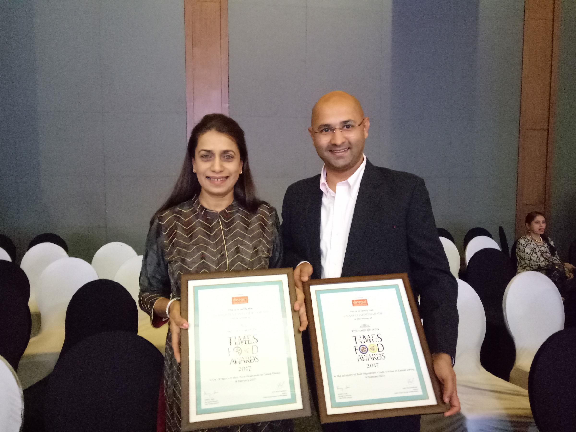 The founders holding two framed Times Food Awards certificates