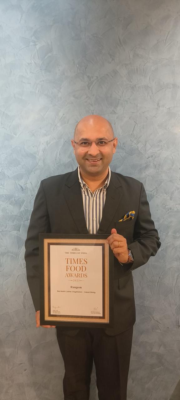 A WeServe founder holding a framed Times Food Awards certificate