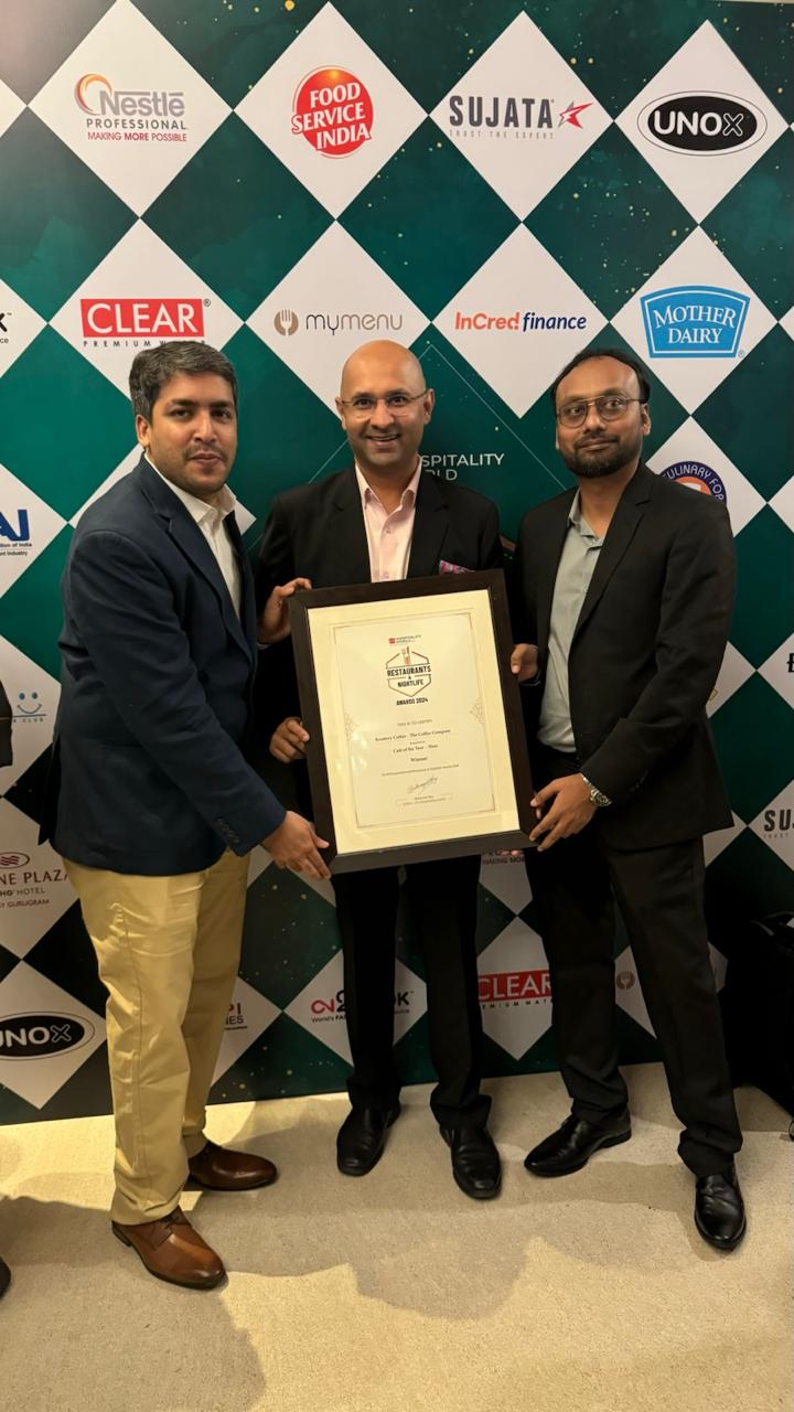 Three team members holding a framed award