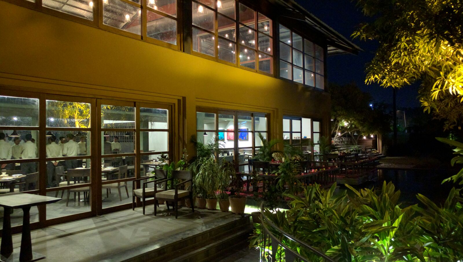 @Mango glass-fronted facade and garden seating at night