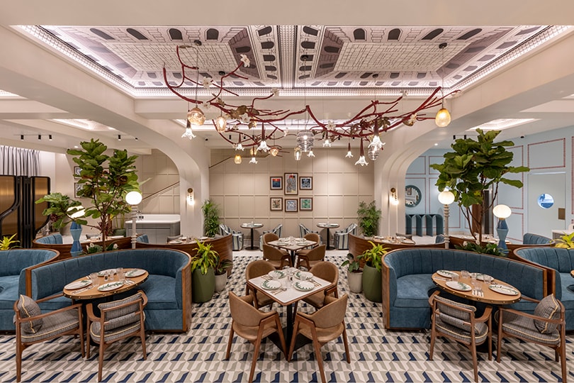 Symmetrical view of the hall with curved blue booths and pendants