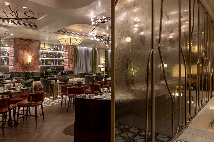 Lounge dining beyond a brass-framed glass partition