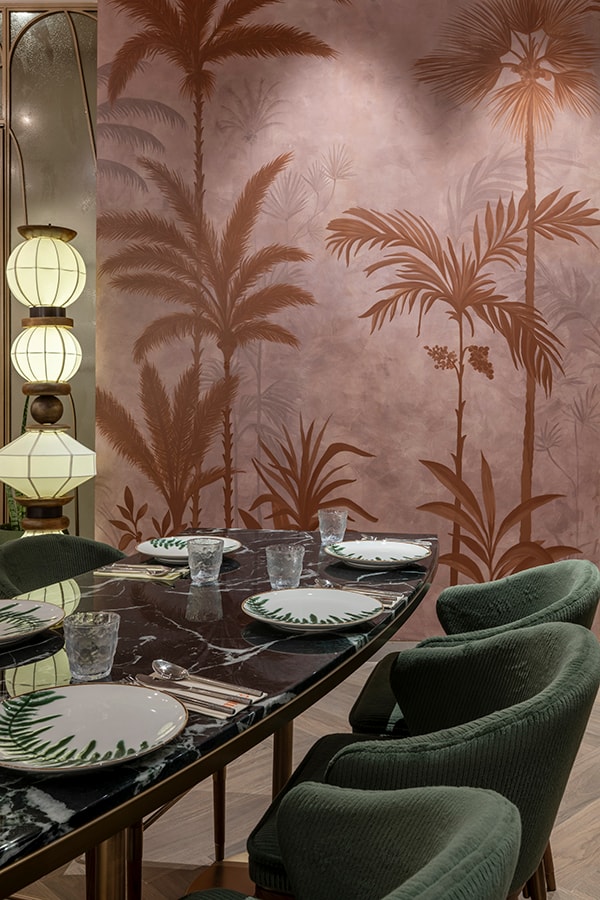 Palm-motif mural wall behind a set table
