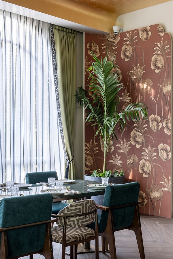 Table by the window with sheer curtains and a floral wall covering