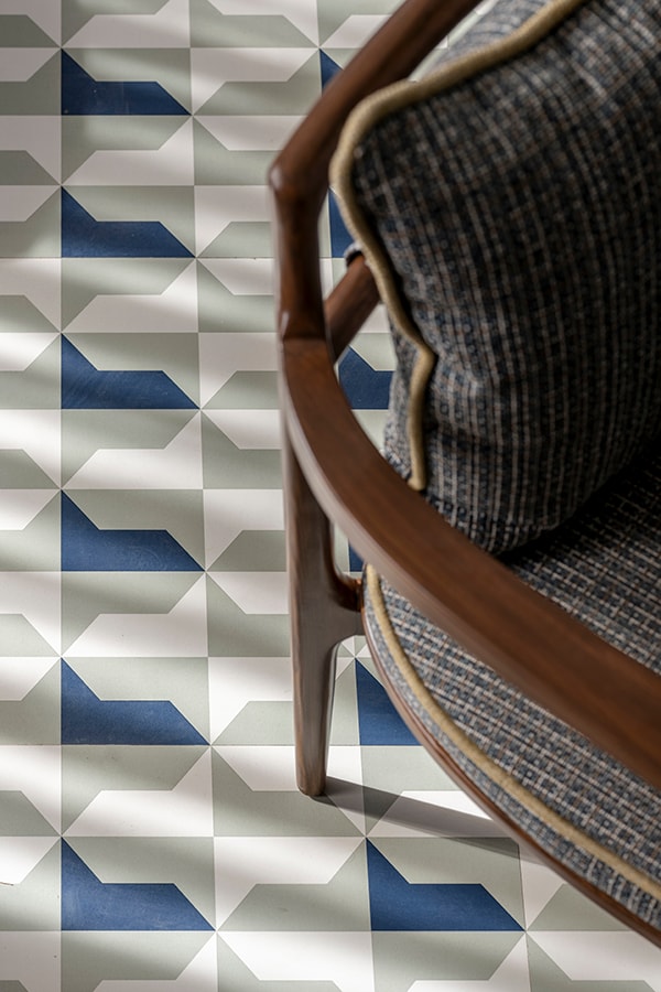 Blue and white tile floor beside a woven-back chair