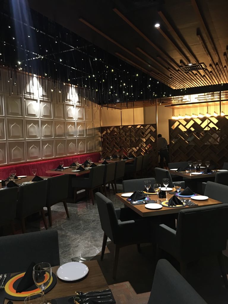 Dining room under a starlit ceiling, framed by timber lattice screens