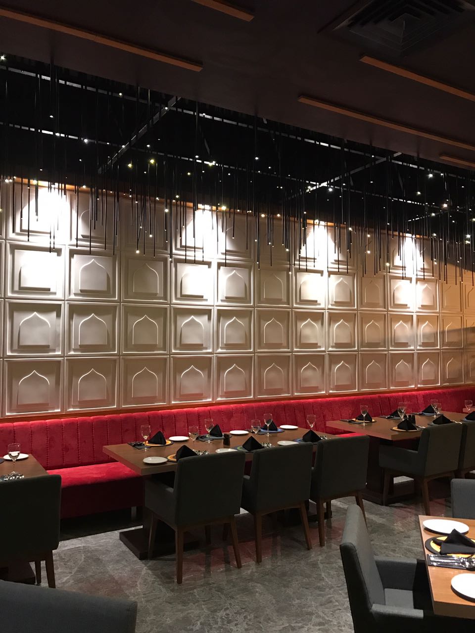 Carved panelled wall and red banquette running the length of the room
