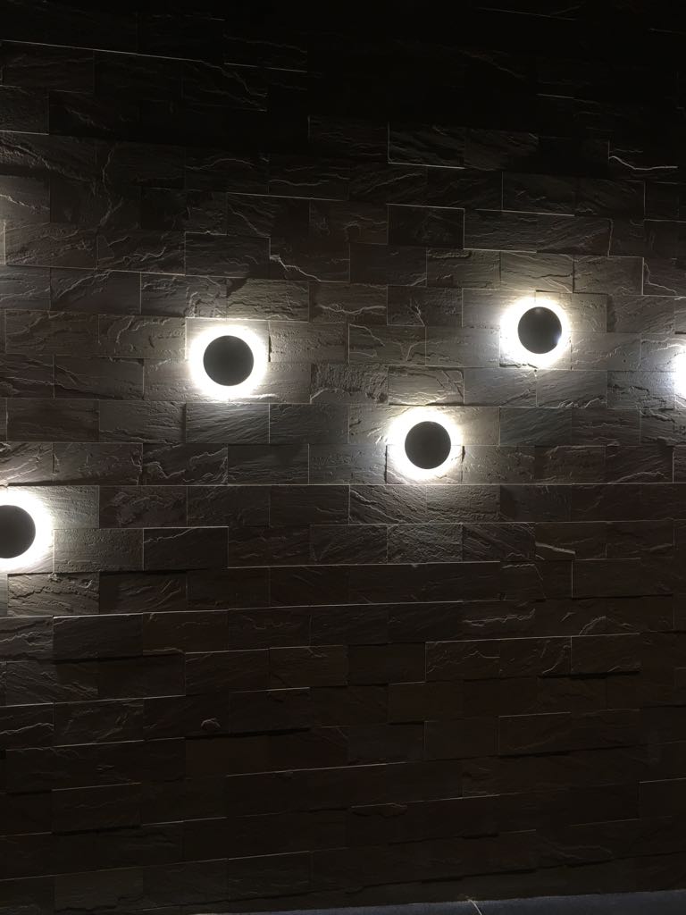 Circular wall lights set into a textured stone wall