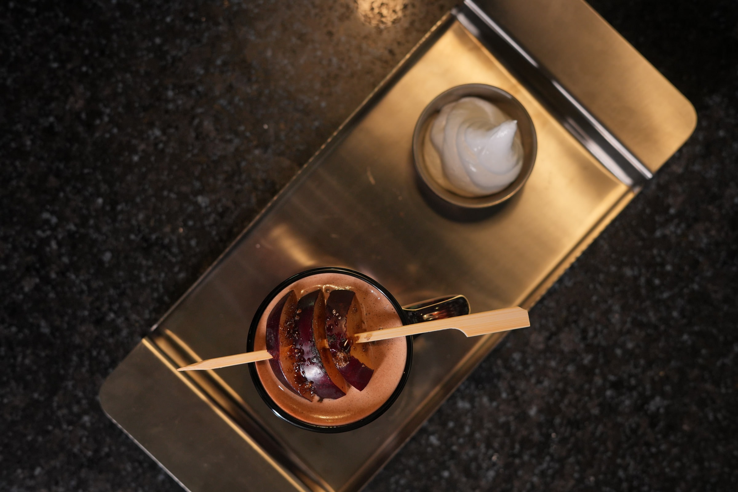 Coffee and a dessert served on a dark marble table