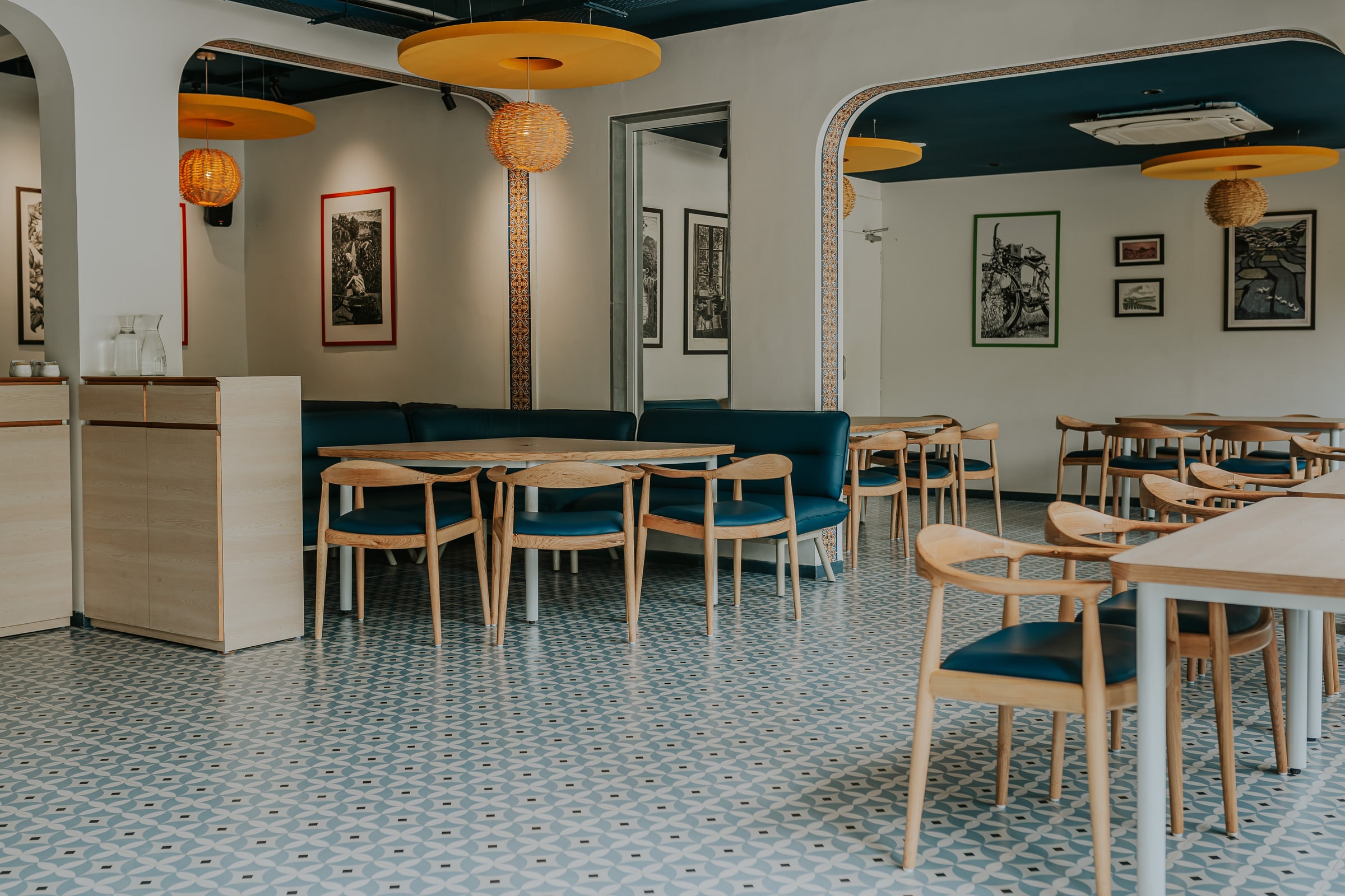 The counter and banquette seating under yellow ceiling discs