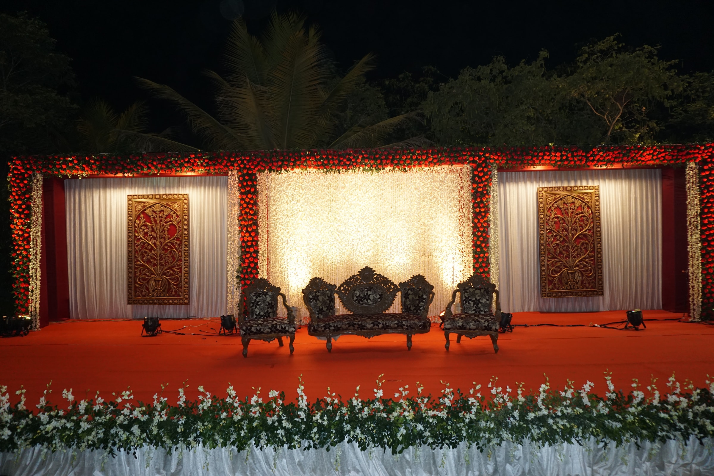 Reception stage with a red carpet and cream draped backdrop