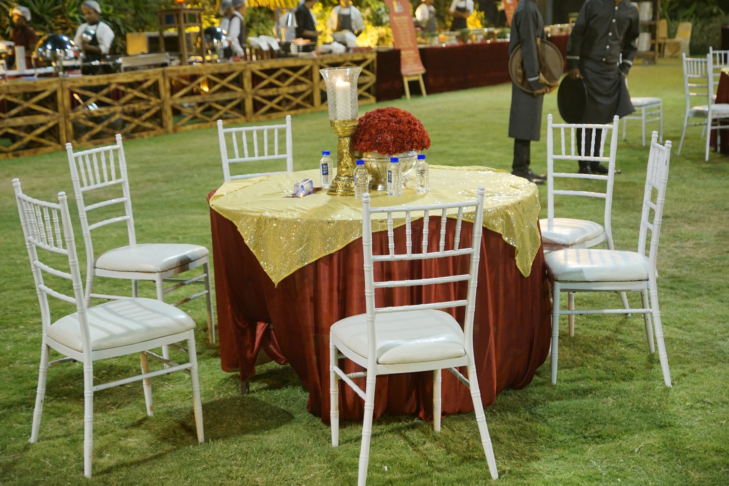 Round table with white chairs and a floral centrepiece on the lawn