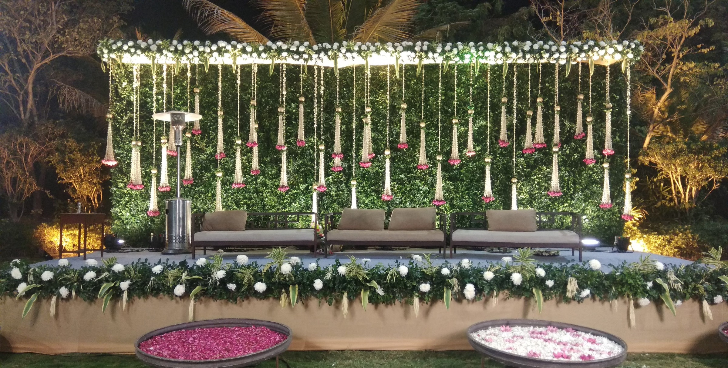 Hanging floral backdrop above a white-flower planter stage