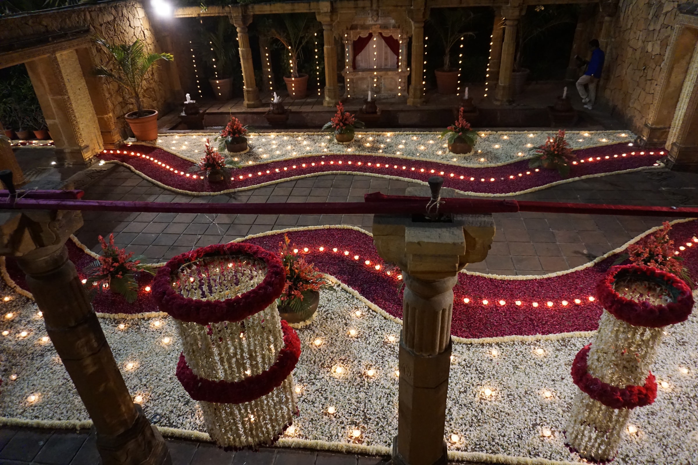 Circular floral installations and lamps on the courtyard floor
