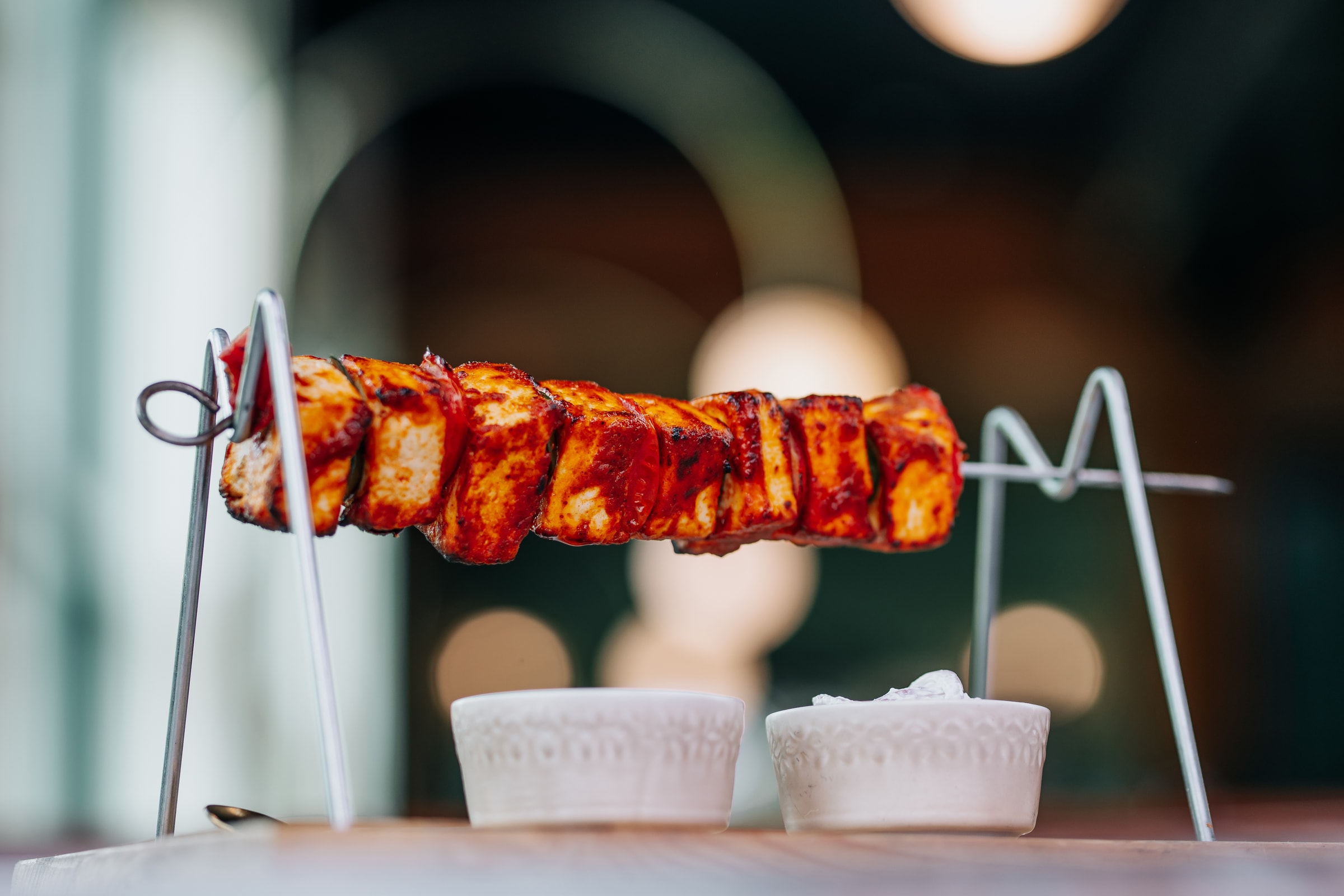 Grilled paneer skewer on a metal stand
